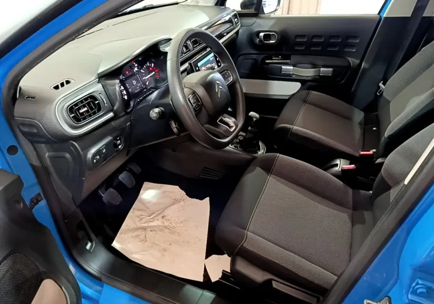 Intérieur avant droit d'une Citroën C3 bleu 2017, montrant sièges tissu et tableau de bord avec écran tactile.
