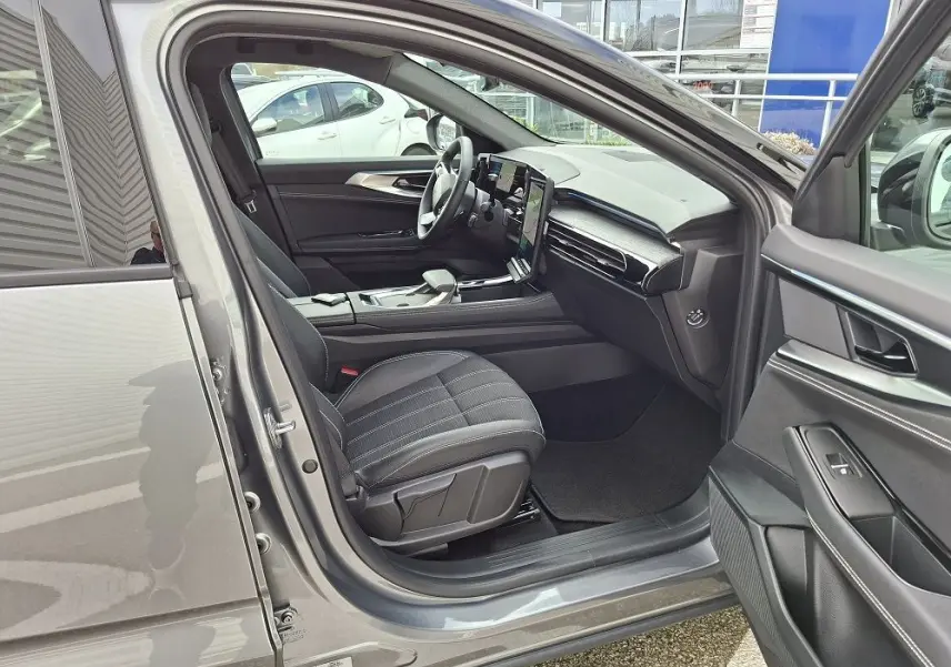 Intérieur avant droit ouvert d’un Renault Austral gris schiste, montrant les sièges noirs et le tableau de bord moderne.