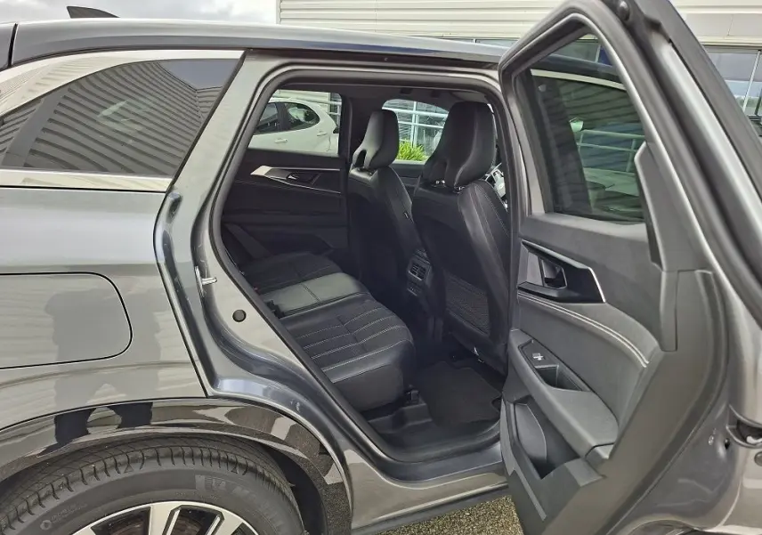 Vue côté gauche arrière du Renault Austral gris schiste, porte ouverte dévoilant l’habitacle et les sièges noirs.