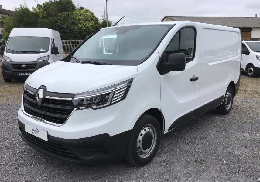 Renault Trafic Fourgon blanc vu en 3/4 avant droit, avec calandre noire et phares LED distinctifs.