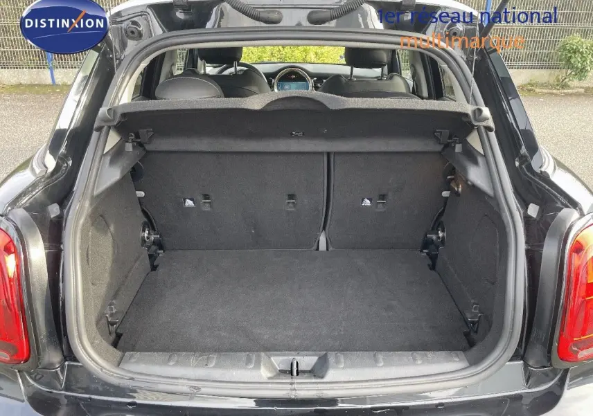 Coffre ouvert d'une MINI 1.5 136CH noir midnight metal, vue arrière montrant l'espace de chargement et l'intérieur des sièges.