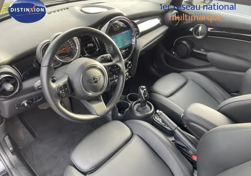 Intérieur noir cuir d'une MINI 1.5 136CH STEPTRONIC 2023, vue depuis le côté conducteur sur le tableau de bord et la console centrale.