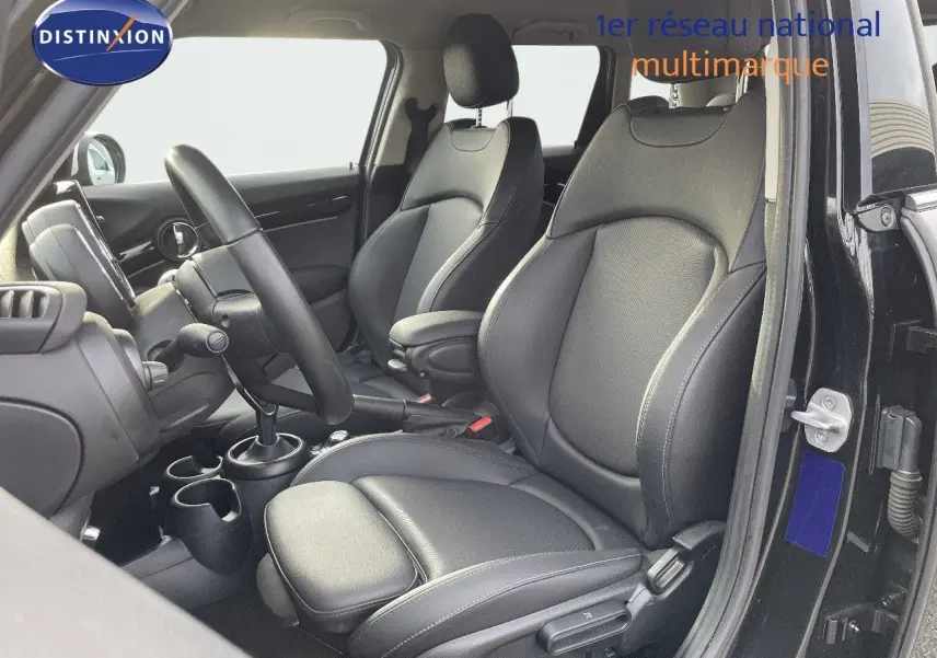 Intérieur de la MINI 1.5 136CH noir, vue côté conducteur montrant les sièges en cuir noir et la console centrale.