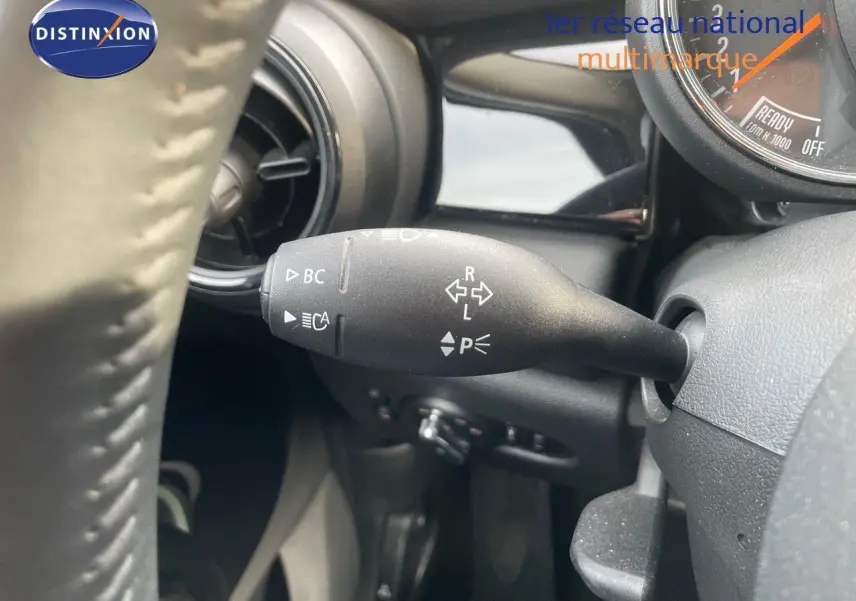 Gros plan sur la manette de clignotant à gauche du volant dans l'habitacle d'une MINI noire 2023.