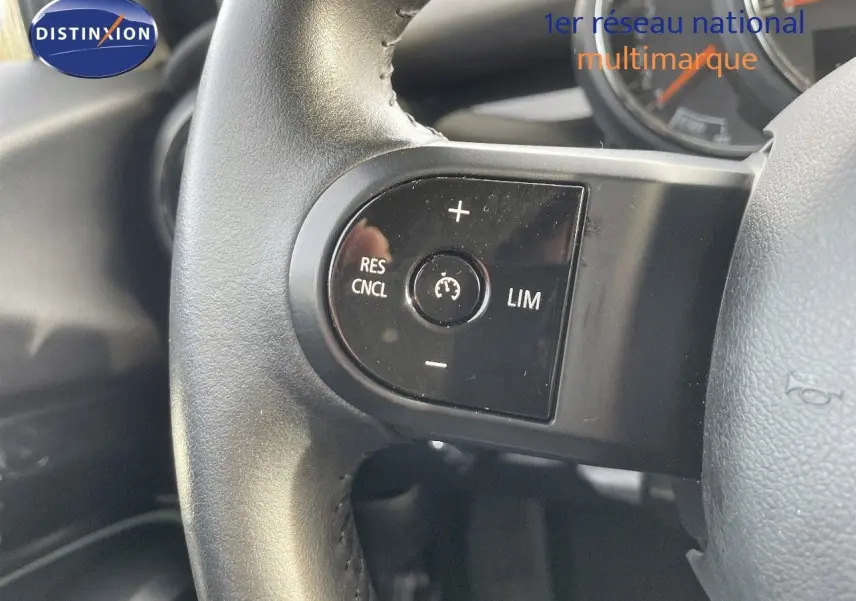 Gros plan sur les commandes de régulateur de vitesse au volant cuir noir d'une MINI 2023 Midnight Metal.