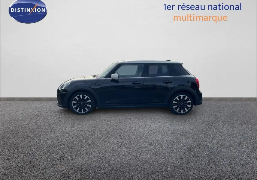 Profil côté gauche d'une MINI 1.5 136CH noire Midnight Metal avec toit blanc et jantes bi-ton 17 pouces.