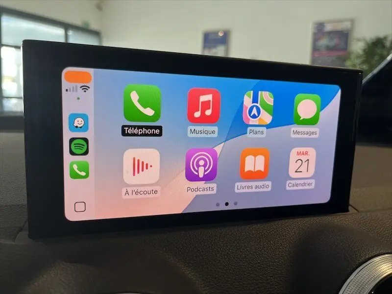 Écran tactile multimédia de l'Audi Q2 30 TFSI S-Line 2021 affichant les applications Apple CarPlay dans l'habitacle.