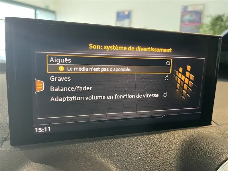 Écran central de l'Audi Q2 30 TFSI S-Line 2021 affichant les réglages audio avec interface moderne sur tableau de bord noir.