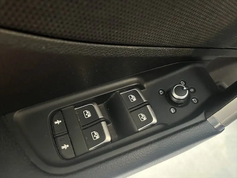 Commandes des vitres électriques et réglage des rétroviseurs côté conducteur dans un Audi Q2 bleu Navarre Metal 2021.
