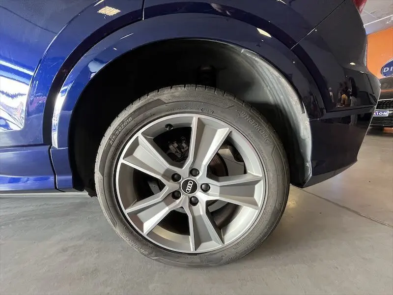 Gros plan sur la roue avant gauche de l'Audi Q2 30 TFSI S-Line bleu Navarre métal, mettant en valeur la jante alliage 5 branches.