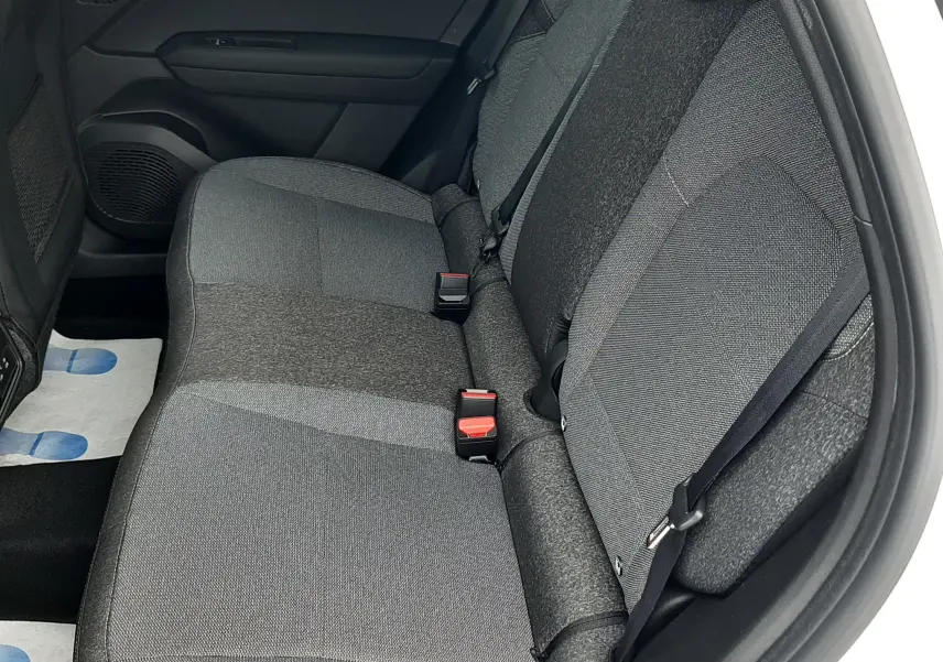 Vue intérieure côté droit des sièges arrière gris foncé du Renault Symbioz blanc nacré, avec ceintures de sécurité visibles.