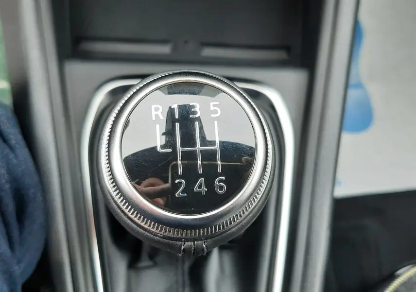 Gros plan sur le levier de vitesses manuel noir avec marquages blancs dans l’habitacle d’une Renault Symbioz.