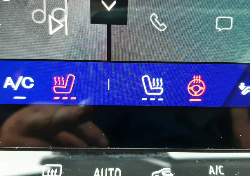 Vue rapprochée de l'écran tactile intérieur montrant les commandes de sièges et volant chauffants du Renault Symbioz blanc nacré.