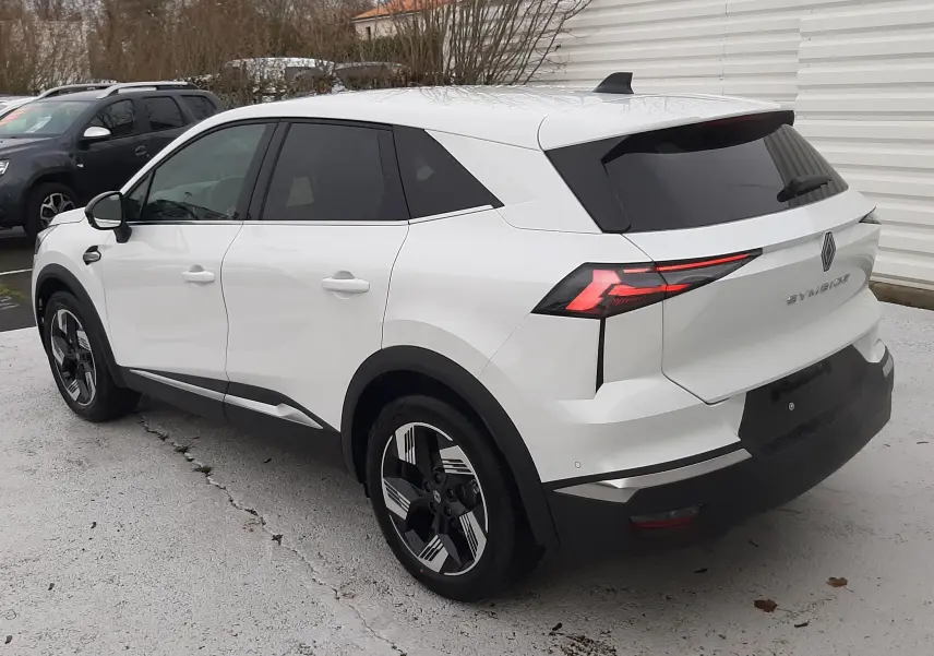 Vue 3/4 arrière droite d'un Renault Symbioz blanc nacré avec feux arrière LED et jantes bicolores modernes.