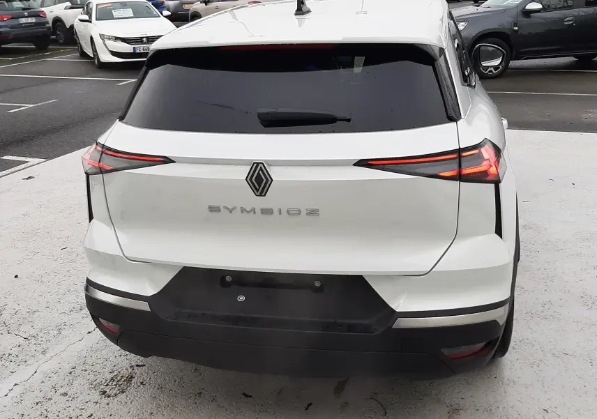 Vue arrière d'une Renault Symbioz blanc nacré avec feux arrière LED étirés et lunette arrière teintée.
