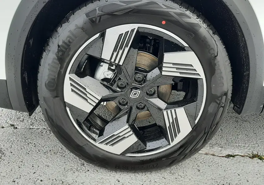 Gros plan sur la roue avant droite du Renault Symbioz blanc nacré avec jante alliage bicolore au design moderne.