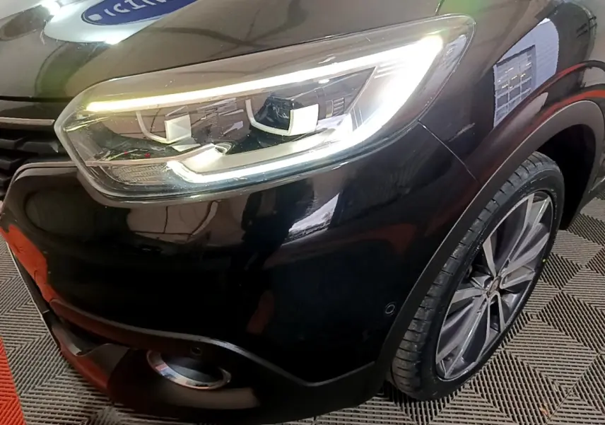 Gros plan sur l'avant droit noir du Renault Kadjar Intens avec phare LED allumé et jante alliage visible.
