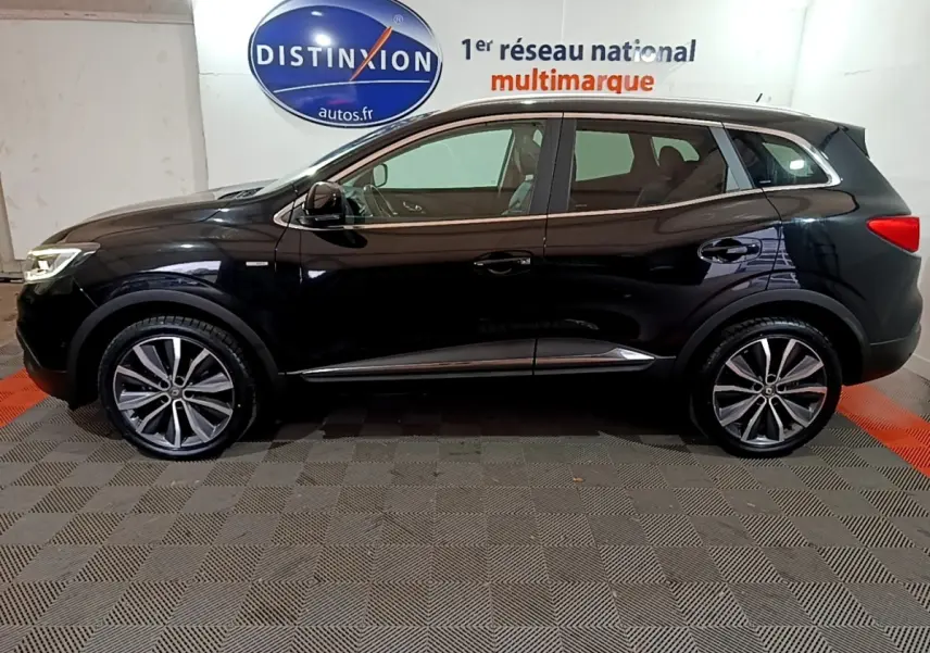 Profil côté gauche du Renault Kadjar noir 2018 avec jantes alliage et vitres teintées en intérieur showroom.