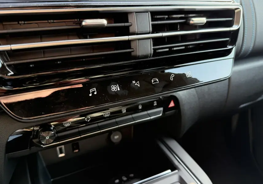 Détail intérieur du tableau de bord noir brillant du Citroën C5 Aircross 2025, avec commandes tactiles et aérateurs.