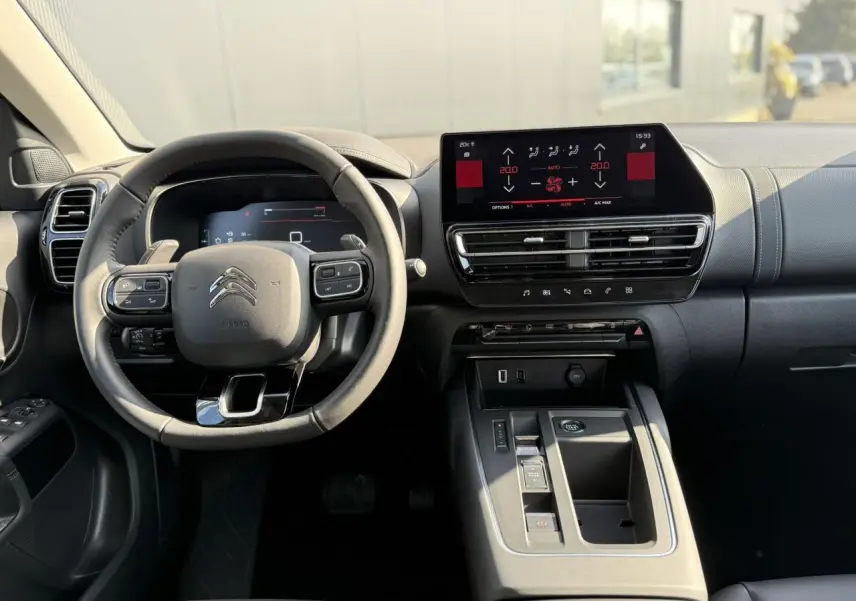 Vue intérieure avant du Citroën C5 Aircross 2025, tableau de bord noir avec écran tactile et volant cuir.