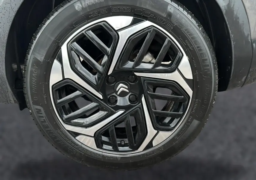 Gros plan sur la jante alu bicolore noire et argentée d'une Citroën C4 gris 2024 avec pneu Michelin.