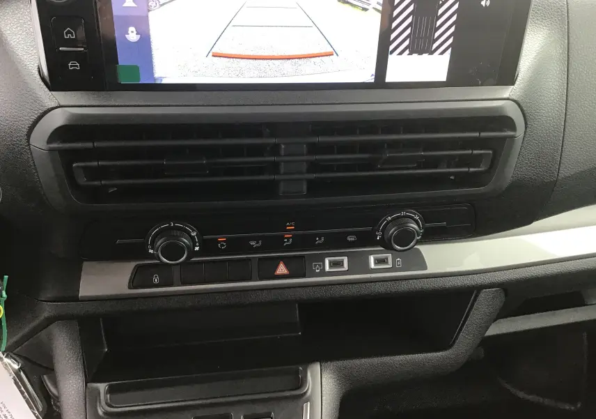 Gros plan sur la console centrale du Citroën Jumpy Gris Titane, affichant la caméra de recul et les commandes de climatisation.