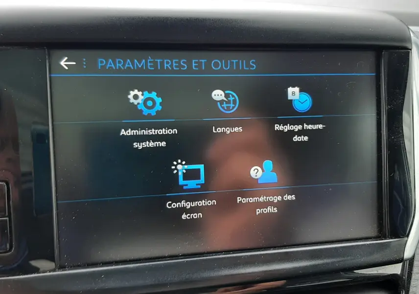 Écran tactile du tableau de bord du Peugeot 2008 blanc, affichant les paramètres et outils du système multimédia.