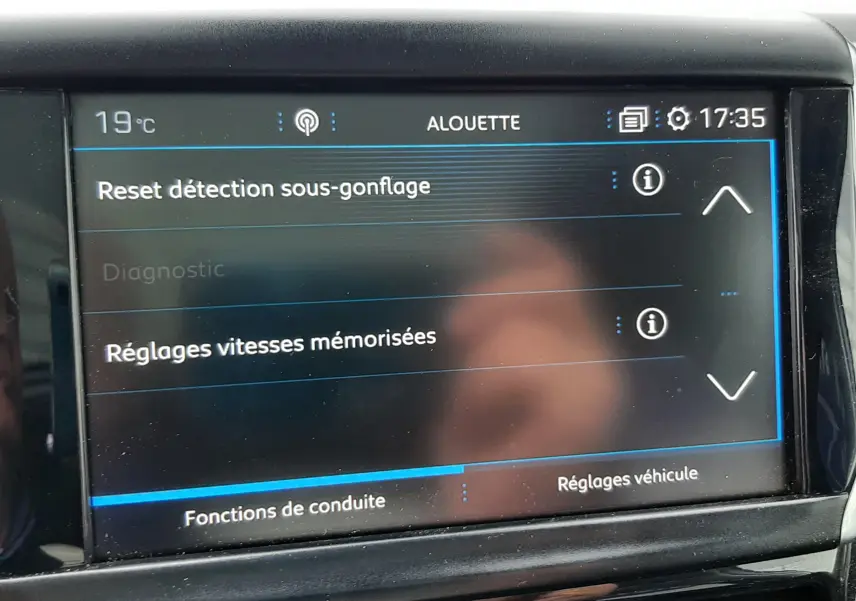 Écran tactile central du tableau de bord d'une Peugeot 2008 blanc, affichant les réglages de conduite et détection sous-gonflage.