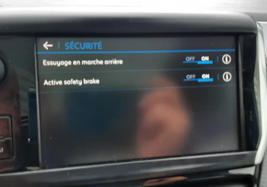 Écran central du tableau de bord du Peugeot 2008 affichant les options de sécurité activées, intérieur noir.
