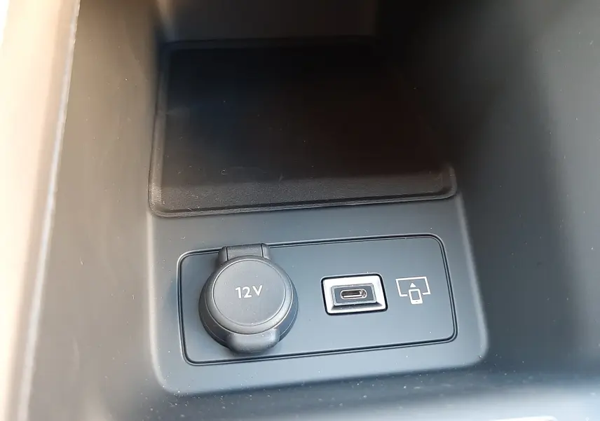 Prise 12V et port USB-C en gros plan dans la console centrale d'une Peugeot 308 Bleu Obsession 2025.