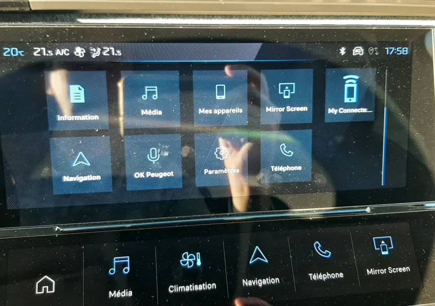 Écran tactile central du tableau de bord de la Peugeot 308 Bleu Obsession, affichant les menus multimédia et navigation.