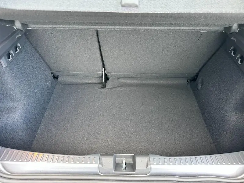 Vue intérieure du coffre spacieux et propre du Dacia Sandero blanc Glacier 2025, avec banquette arrière rabattable.