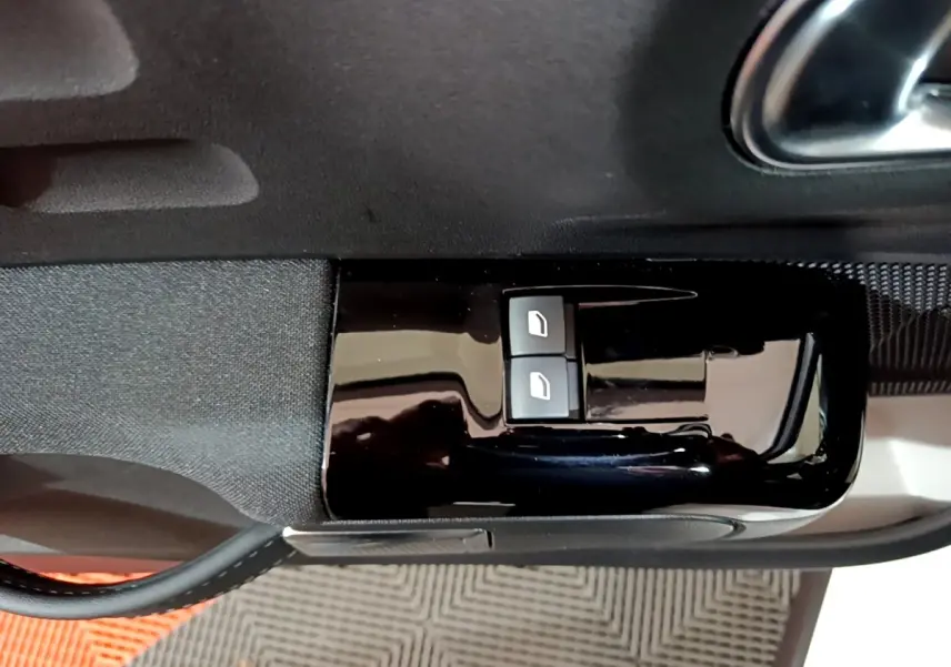 Boutons de commande des vitres électriques sur la porte intérieure côté conducteur d'une Citroën C3 blanche 2023.