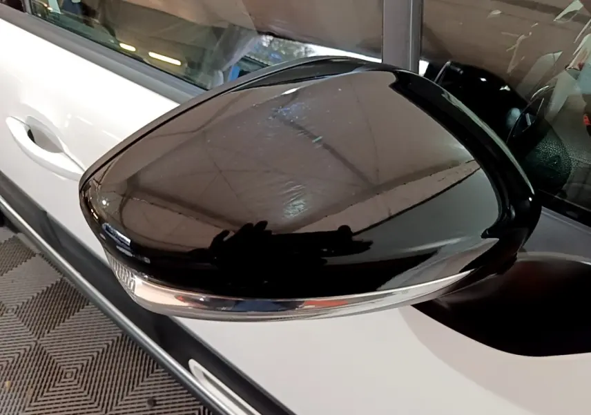 Rétroviseur noir brillant côté gauche d'une Citroën C3 blanche PureTech 83 Shine 2023, vue rapprochée.