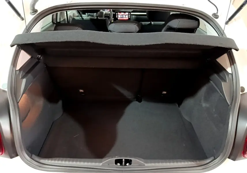 Coffre ouvert vu de l'arrière d'une Citroën C3 blanche 2023, montrant l'espace de chargement et banquette arrière.