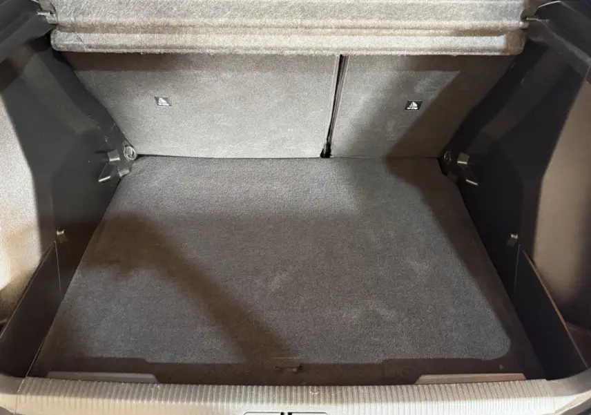 Coffre spacieux de Peugeot 2008 2022 vue de dessus, intérieur noir avec banquette rabattue, sans chargement visible.