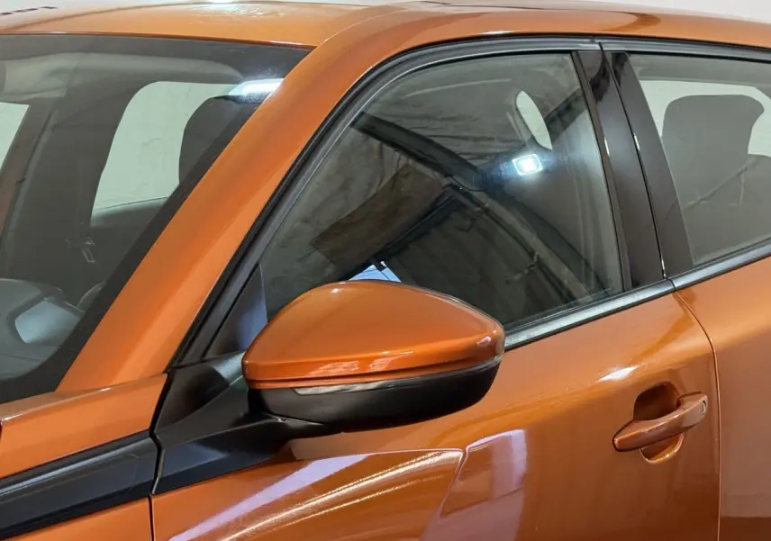 Vue rapprochée du rétroviseur côté gauche et de la porte orange d’un Peugeot 2008 2022 en finition Active Business.