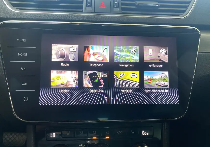 Écran tactile central du tableau de bord du Skoda Superb Combi bleu énergie, affichant le menu multimédia et navigation.