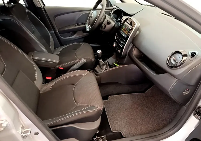 Vue intérieure côté passager de la Renault Clio Business TCe 90 gris clair, avec tableau de bord et sièges noirs.