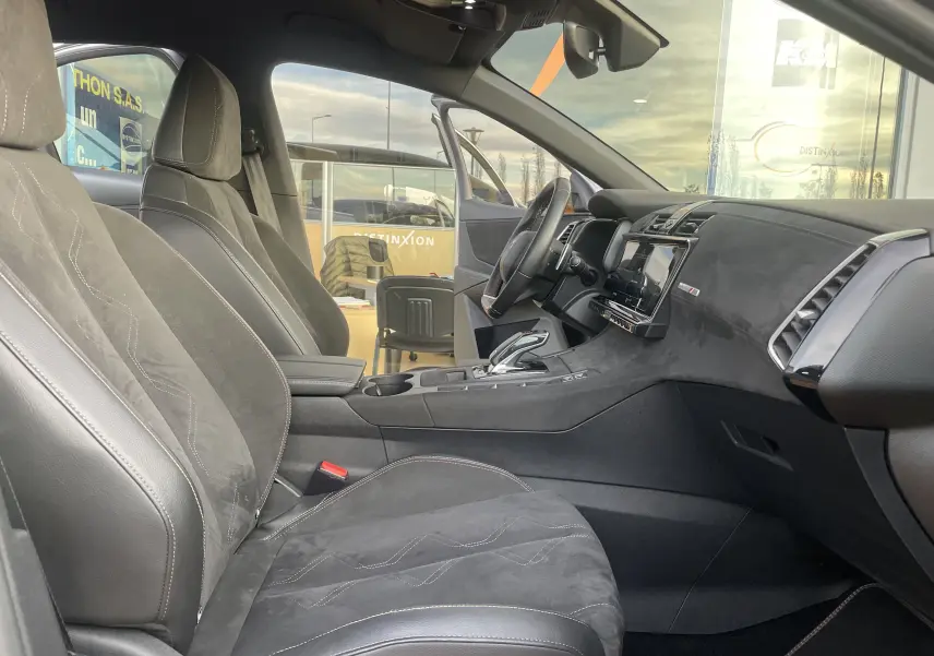 Intérieur avant droit du DS7 gris 2021, sièges en cuir et alcantara, tableau de bord moderne avec écran tactile central.