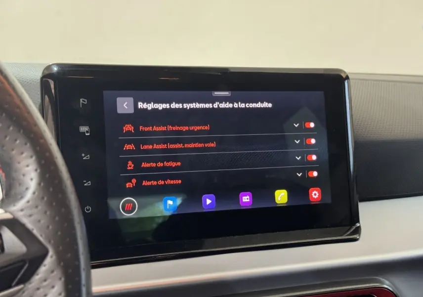 Écran tactile central affichant les réglages d'aide à la conduite dans l'habitacle d'une SEAT Ibiza rouge 2024.