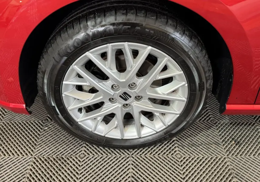 Gros plan sur la roue avant gauche avec jante argentée et logo SEAT sur une SEAT IBIZA rouge 2024.