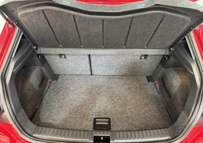 Coffre ouvert vu de face d'une SEAT IBIZA rouge 2024, montrant un espace de chargement propre et spacieux.