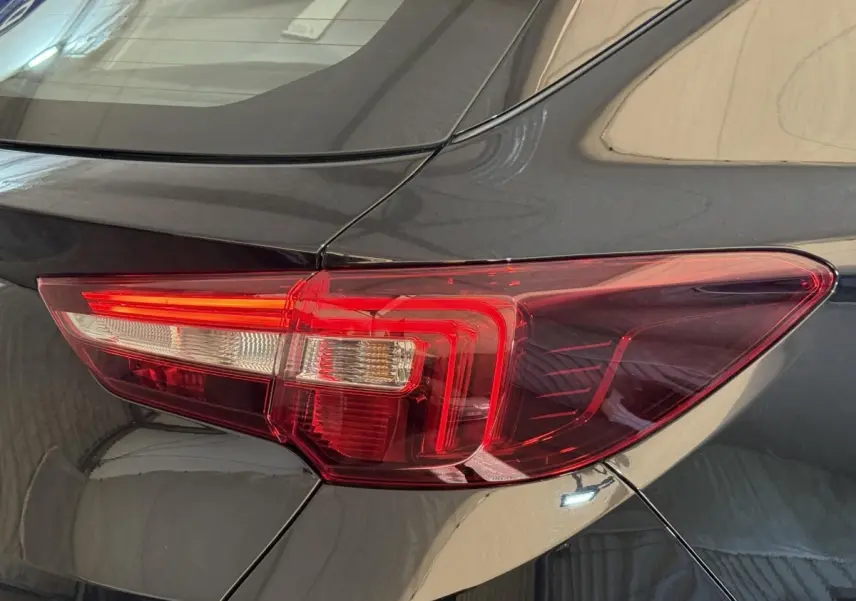 Gros plan sur le feu arrière droit rouge du SUV Opel Grandland X noir, montrant la carrosserie brillante.