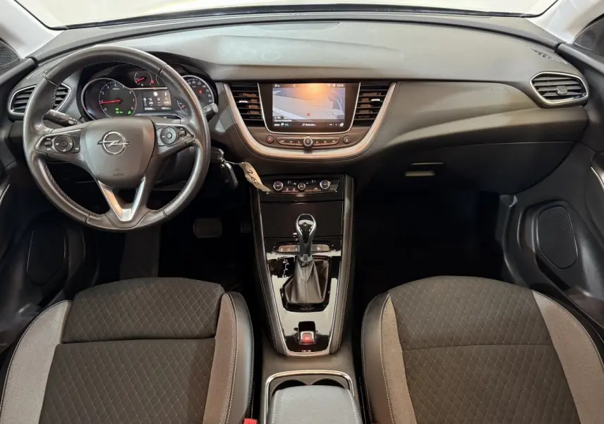 Vue intérieure frontale de l’Opel Grandland X 2021, volant cuir, écran tactile central et sièges tissu gris foncé.
