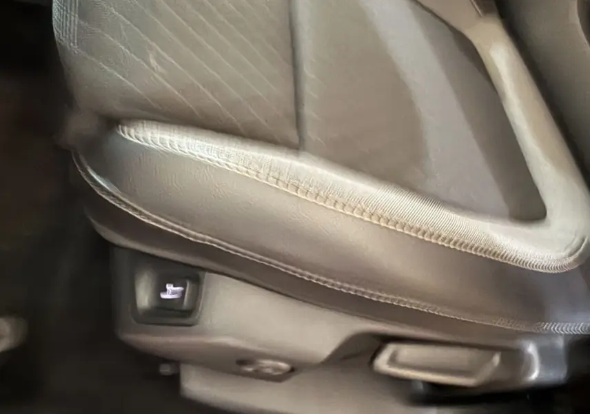 Détail du siège avant en cuir gris clair de l’Opel Grandland X, bouton de réglage électrique visible sous l’assise.