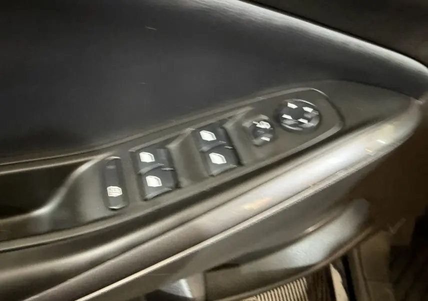 Gros plan sur la commande des vitres électriques et réglages des rétroviseurs côté conducteur de l’Opel Grandland X noir.