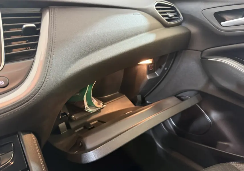 Vue intérieure côté passager de l'Opel Grandland X 2021, boîte à gants ouverte avec éclairage intérieur noir.