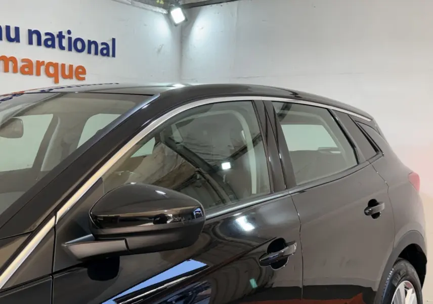 Vue latérale côté gauche d'un Opel Grandland X noir brillant, mettant en valeur la porte et le rétroviseur extérieur.