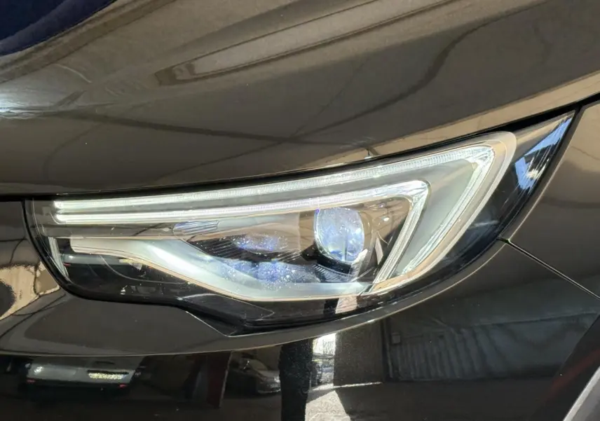 Gros plan sur le phare avant droit du SUV Opel Grandland X noir, mettant en valeur son design LED moderne.
